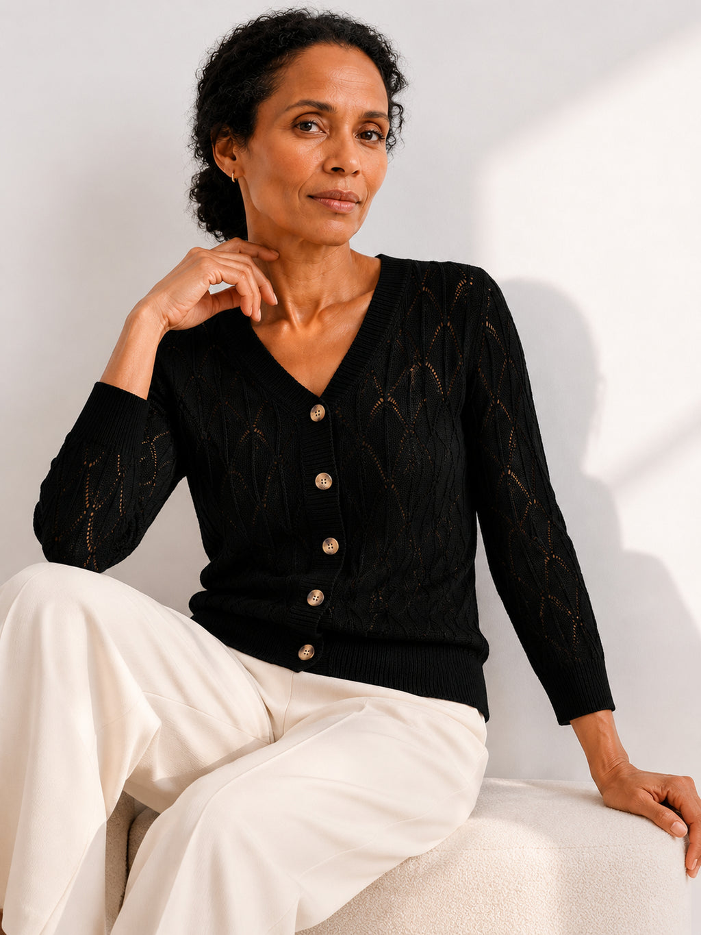 MY021 black openwork v-neck three-quarter sleeve cardigan seated model view